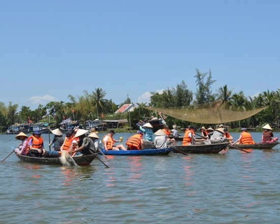 Visitors row boats in Tra Nhieu community-based tourism village