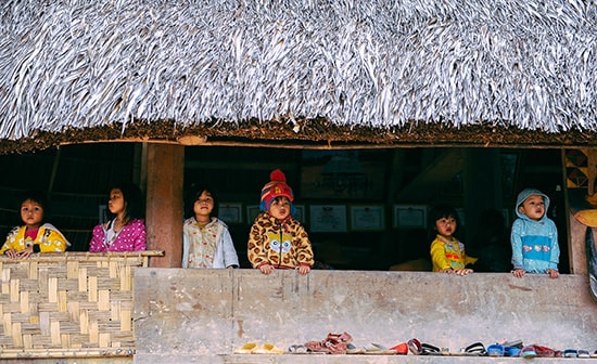 Trẻ em chơi đùa trong nhà sàn, giữa tiết trời lạnh giá.