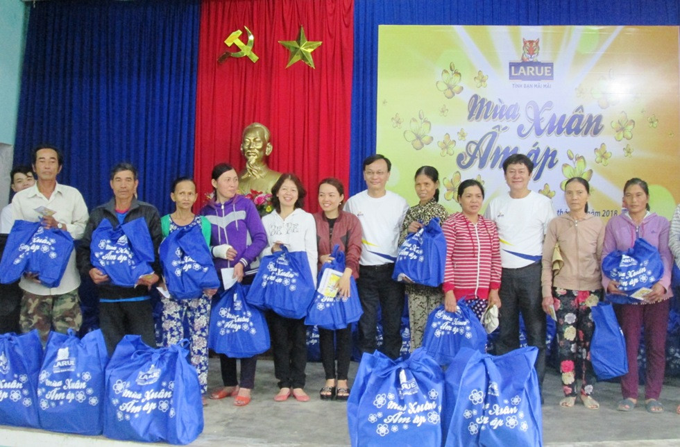 Lãnh đạo Công ty TNHH Nhà máy bia Heineken Việt Nam – Quảng Nam trao quà tết cho những hộ nghèo ở Duy Xuyên. Ảnh: VĂN SỰ 