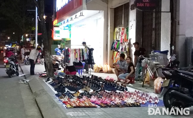 Một đoạn vỉa hè phố chuyên doanh thời trang đường Lê Duẩn từ số nhà 416-420 bị chiếm dụng để buôn bán sau 21 giờ.                                                                      Ảnh: HOÀNG HIỆP