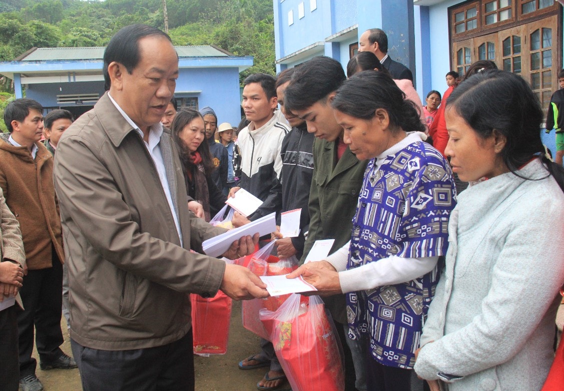 Chủ tịch Đinh Văn Thu trao tặng những phần quà cho người dân xã Trà Bui.