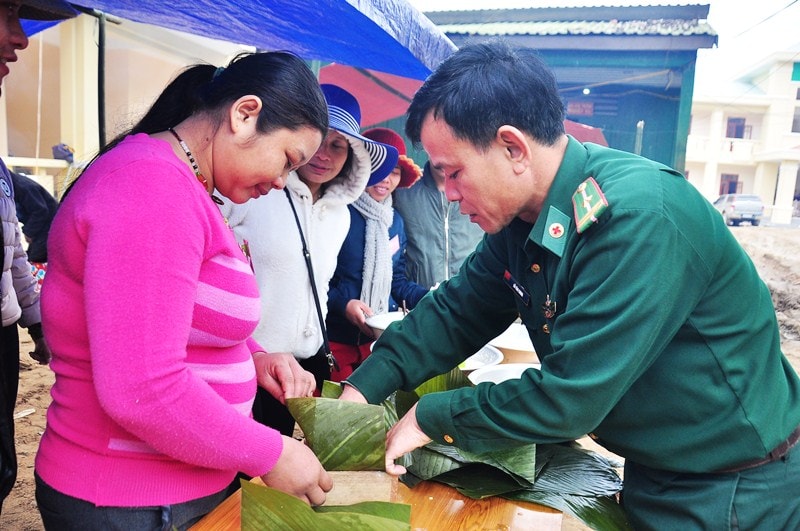 Nhiều chị em lần đầu tiên gói bánh chưng nên phải nhờ đến sự hướng dẫn của bộ đội biên phòng. Ảnh: VINH ANH