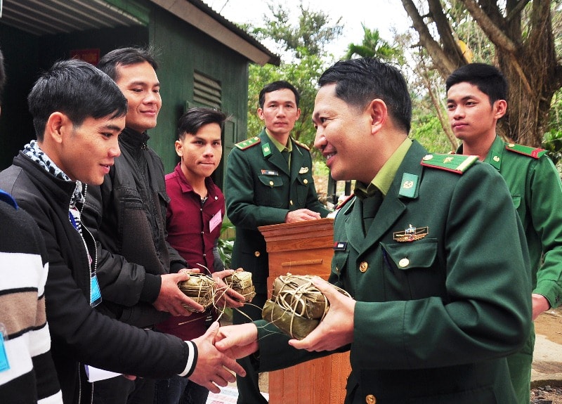 Chỉ huy Đồn Biên phòng Cửa khẩu Nam Giang tặng bánh chưng cho người dân các xã vùng biên giới. Ảnh: VINH ANH