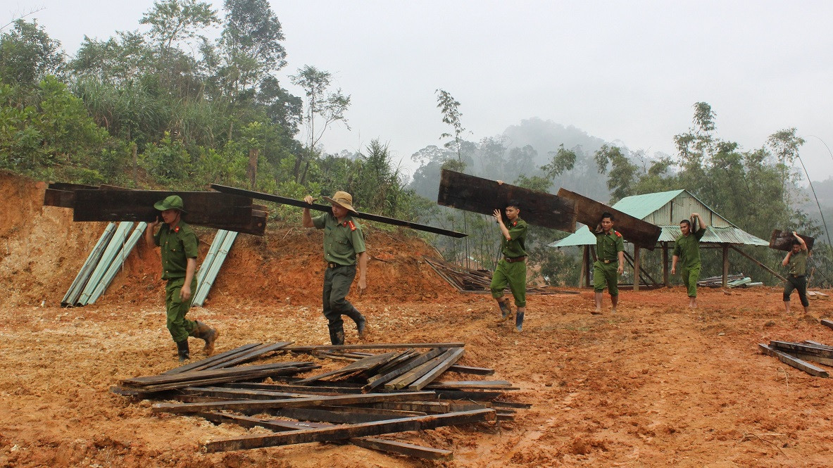 Các chiến sĩ trong Đội xung kích Công an huyện Nam Trà My mang ván về giúp người dân dựng nhà. Ảnh: THANH THẮNG.