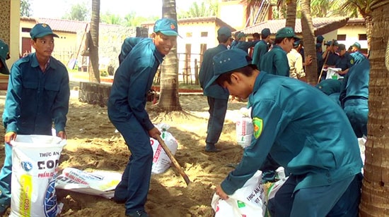 Lực lượng dân quân tham gia kè chống sạt lở bờ biển Cửa Đại.