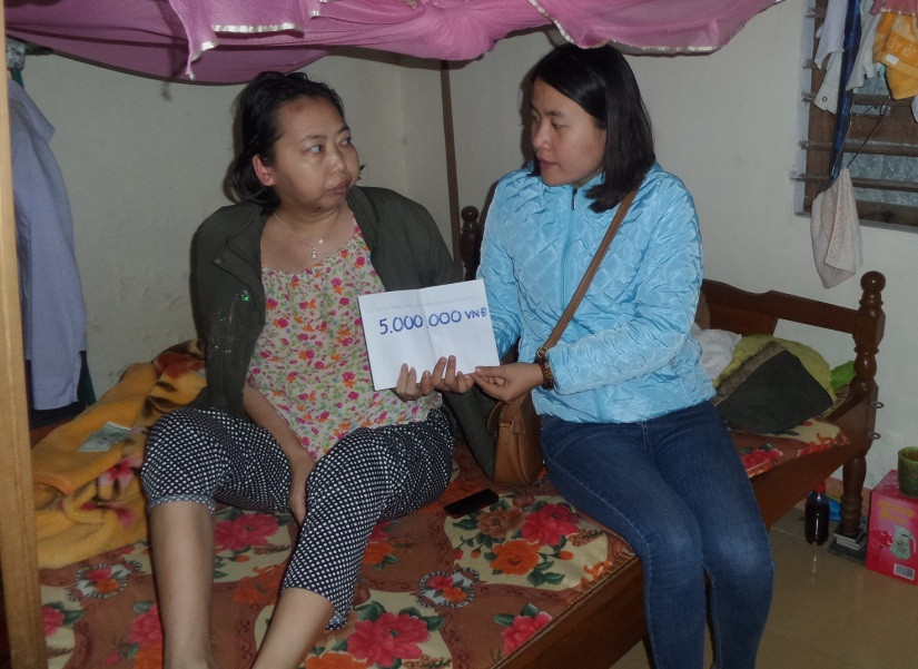 Chị Trịnh Thị Trâm Oanh nhận tiền các nhà hảo tâm giúp đỡ. (ảnh: Như Trang)
