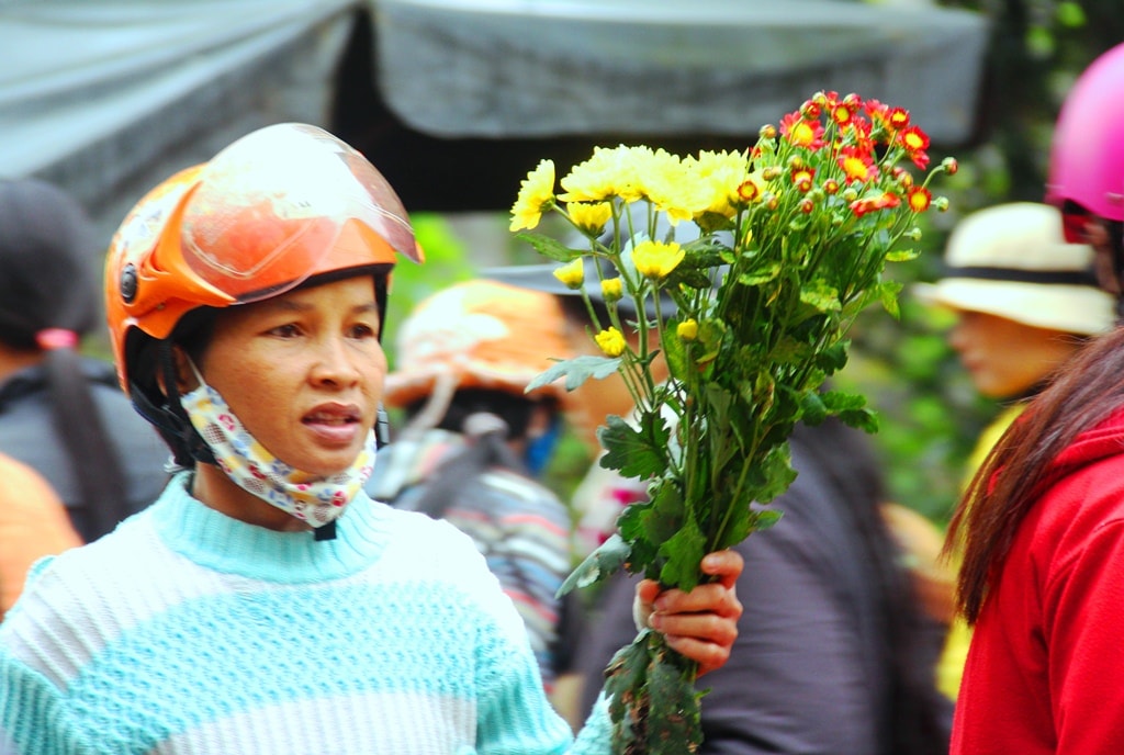 Một phụ nữ vội vã trở về nhà sau buổi ra chợ sớm.