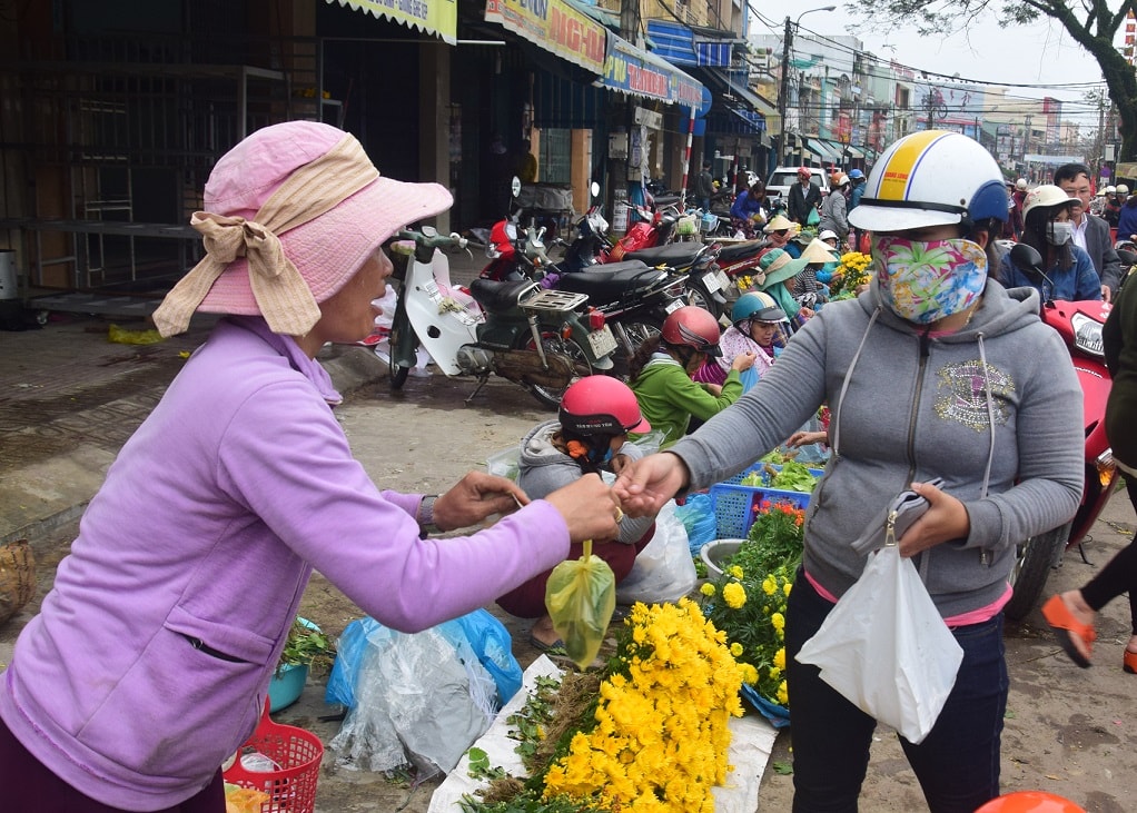 Vừa bán hàng đầu năm, người bán còn chúc người mua một năm mới nhiều may mắn và tài lộc. Ảnh:THANH THẮNG.