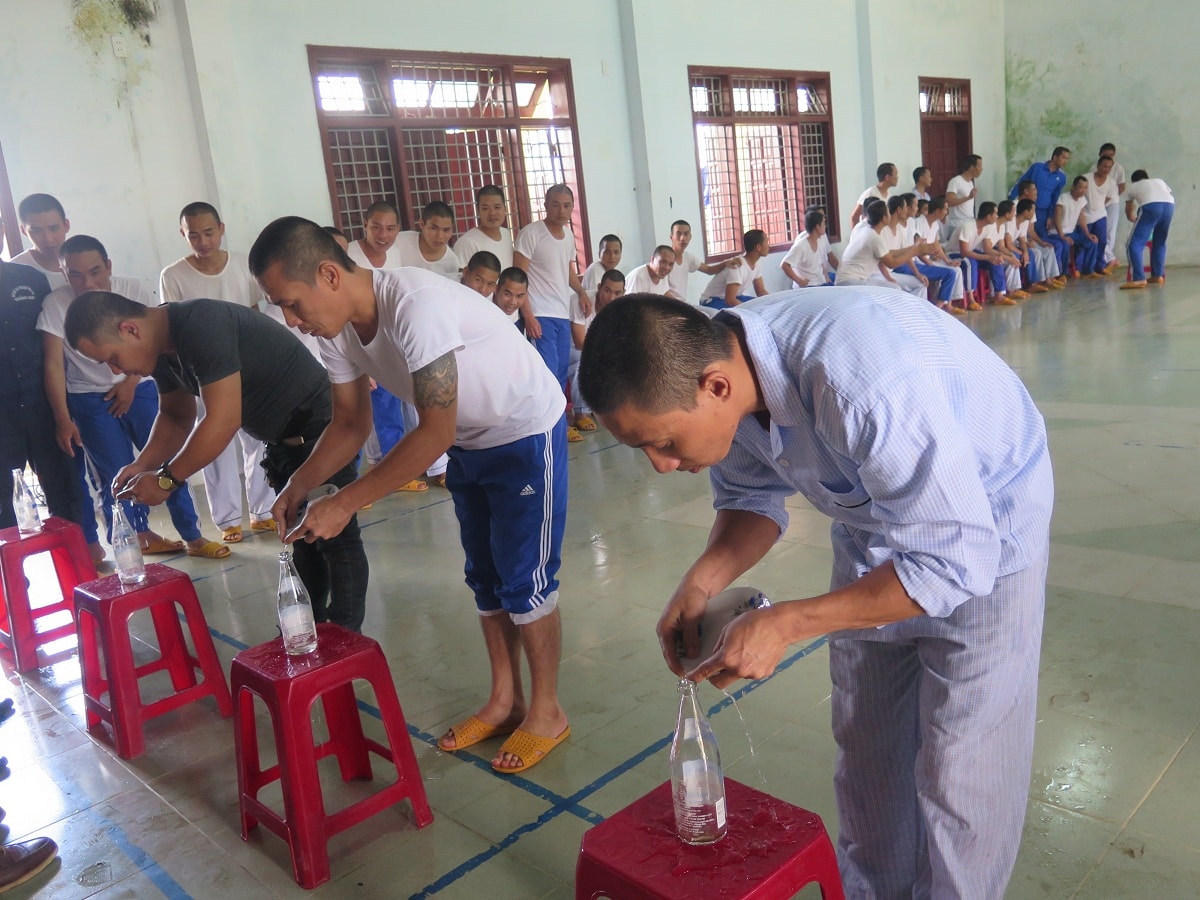 Thi đổ nước vào chai. Ảnh: P.NAM