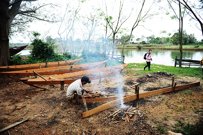 Các thợ đóng thuyền trong làng cũng vào nghề mở hàng. Ảnh: HẢI - LỘC