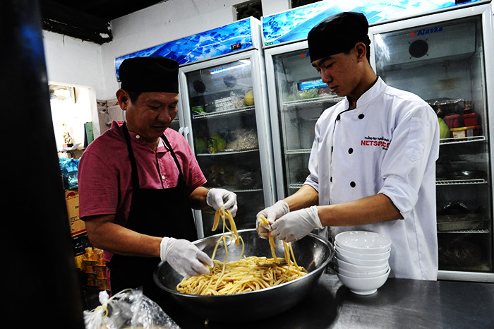 Making cao lau-a regional Vietnamese dish made of noodles, pork, and local greens. It is popular and famous in Hoi An city