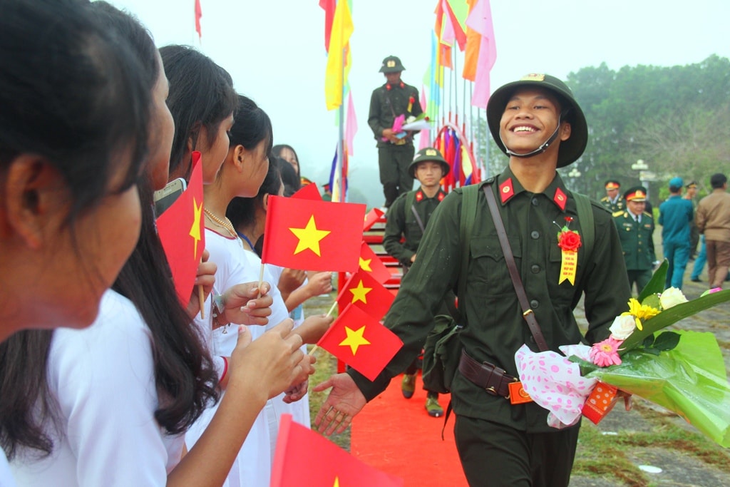 Nụ cười tươi của một tân binh trước những lời chúc và động viên từ các em học sinh nữ. Ảnh: ALĂNG NGƯỚC