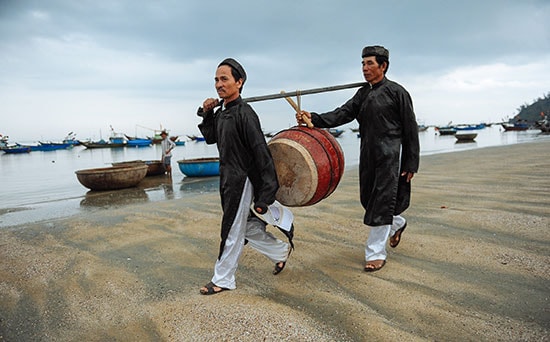 Hai lão ngư khiêng trống đến lễ hội để thực hiện nghi lễ.