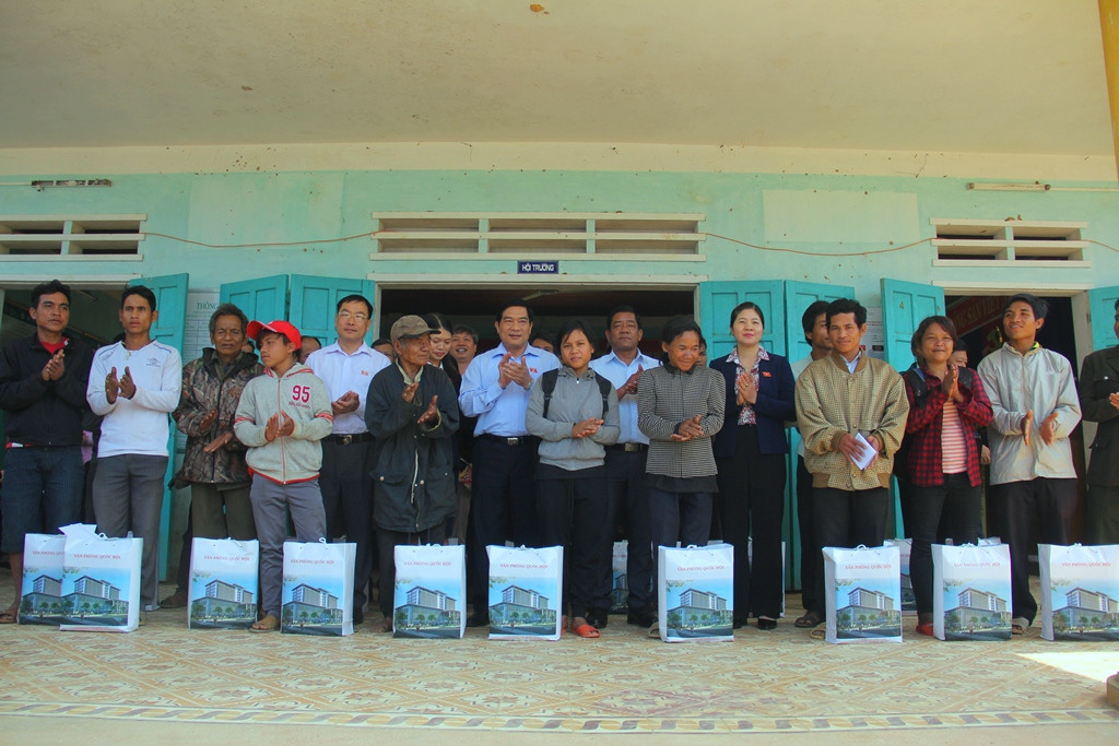 Các hộ dân khó khăn của xã Trà Vân nhận món quà và chụp ảnh lưu niệm với đoàn công tác. Ảnh: A.N
