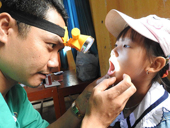 Bác sĩ khám răng cho học sinh.Ảnh: ĐÔNG HẢI