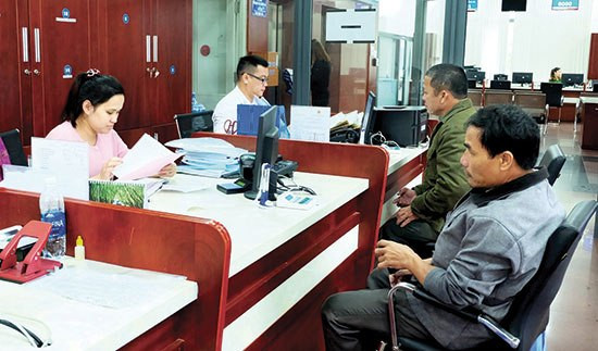 Công dân giao dịch giải quyết hồ sơ thủ tục tại Trung tâm Hành chính công và xúc tiến đầu tư Quảng Nam. Ảnh: VĂN HÀO