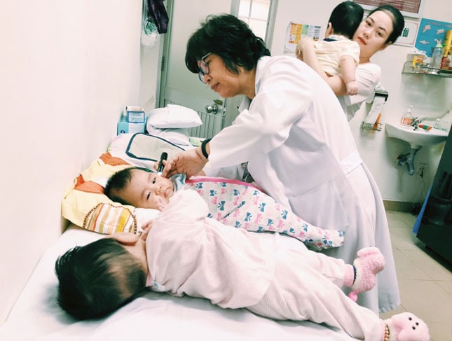 Tiện ích hẹn giờ khám, chữa bệnh là bước đột phá trong cải cách hành chính cần được nhân rộng. TRONG ẢNH: Bác sĩ Bệnh viện Phụ nữ thành phố Đà Nẵng kiểm tra toàn diện sức khỏe trẻ em trước khi tiêm chủng.