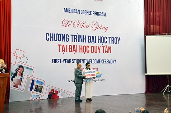 Thầy Lê Công Cơ trao học bổng cho sinh viên thủ khoa Lê Thị Thu Ngân.