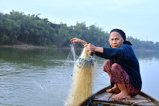 Mặc dù tuổi 80, nhưng bà Hoa vẫn đi thả lưới để đánh cá mòi. Ảnh: XUÂN THỌ