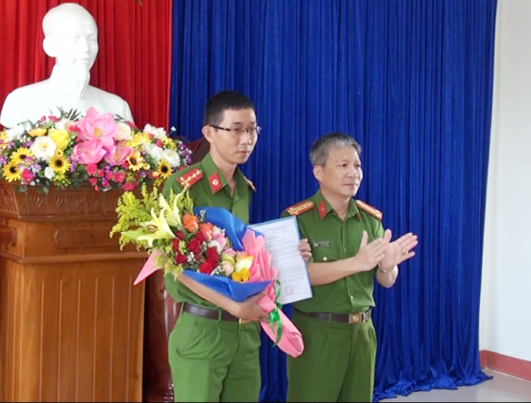 Đại tá Nguyễn Đức Dũng, PGĐ Công an tỉnh trao quyết định, tặng hoa cho đại úy Phạm Việt Ân, Đội trưởng Đội Cảnh sát phòng chống tội phạm sử dụng công nghệ cao