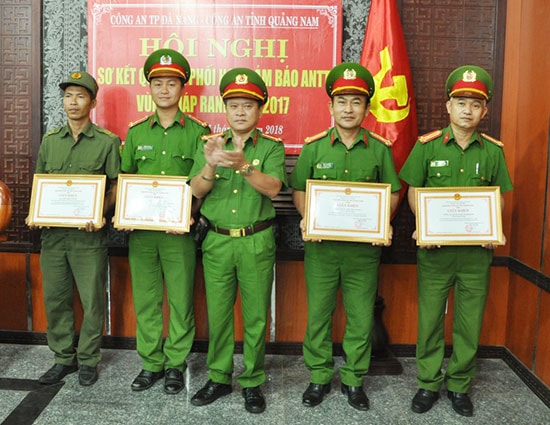 Đại tá Trương Quang Vinh - Phó Giám đốc Công an Quảng Nam trao giấy khen cho các tập thể, cá nhân có thành tích xuất sắc trong thực hiện quy chế phối hợp đảm bảo ANTT vùng giáp ranh. Ảnh: XUÂN MAI