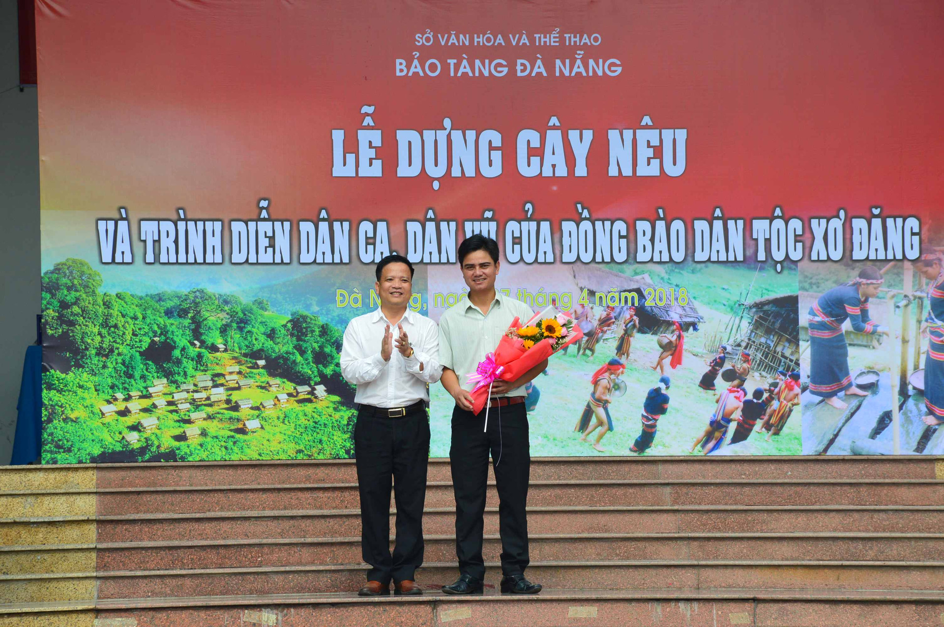 Lãnh đạo Bảo tàng Đà Nẵng tặng hoa lưu niệm cho ông Nguyễn Duy Phương - Chủ tịch UBND xã Trà Nam (phải). Ảnh: Q.T