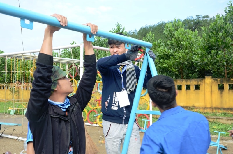 Các bạn tình nguyện lắp đặt khu vui chơi cho trẻ em vùng cao. Ảnh: TỐ UYÊN