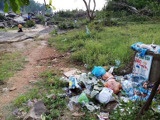 Thùng rác đặt ngay đường xuống bãi đá Lò Thung, rác thải nhiều ngày không được thu gom xử lý tràn ra bên ngoài.