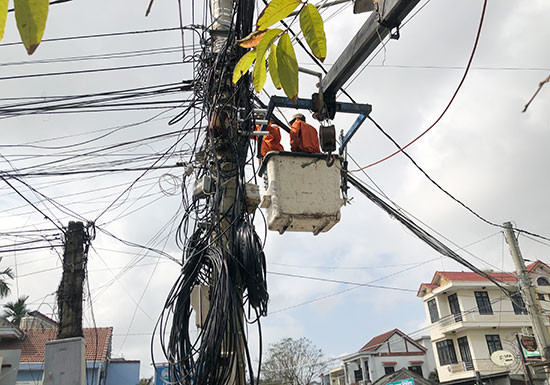 Điện lực Hội An triển khai thi công, bó gọn mạng cáp trên tuyến đường Cửa Đại. Ảnh: T.L