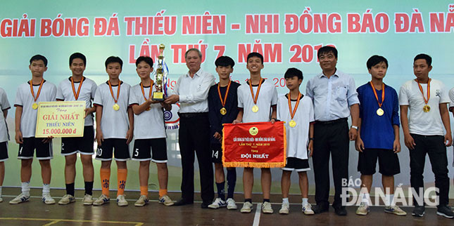Tổng Biên tập Báo Đà Nẵng Trương Công Định (thứ 5, trái sang) và Phó Giám đốc Sở Văn hóa - Thể thao Nguyễn Trọng Thao (thứ 3, phải sang) trao Cúp và Cờ Vô địch cho đội Trường THCS Trần Đại Nghĩa.