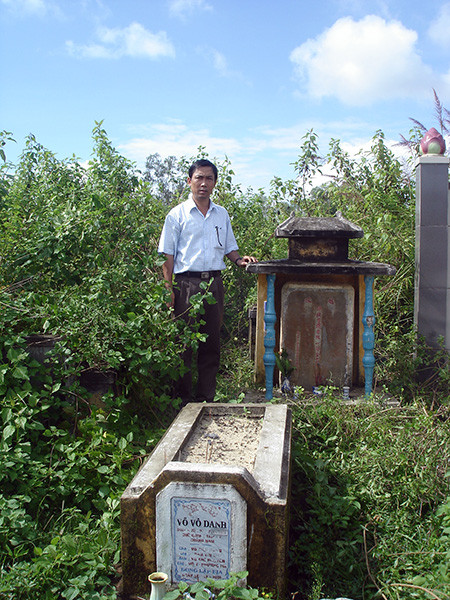 Mộ ông Nguyễn Phước Doãn - tiền hiền thôn Tứ Bàn. Người đứng bên mộ là hậu duệ. Ảnh: Phú Bình