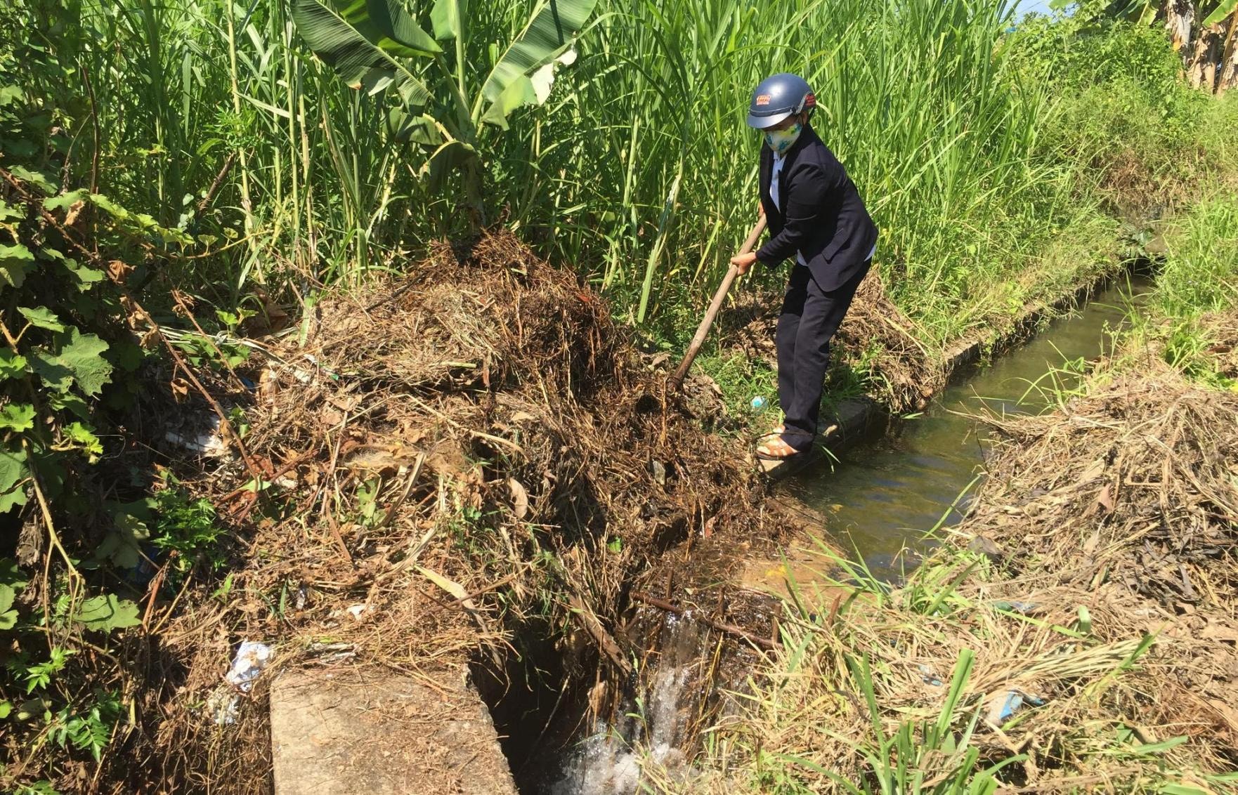 Cán bộ quản lý hồ chứa nhiều lúc phải đi vớt rác để thông kênh đưa nước xuống đồng.. Ảnh: PHAN VINH