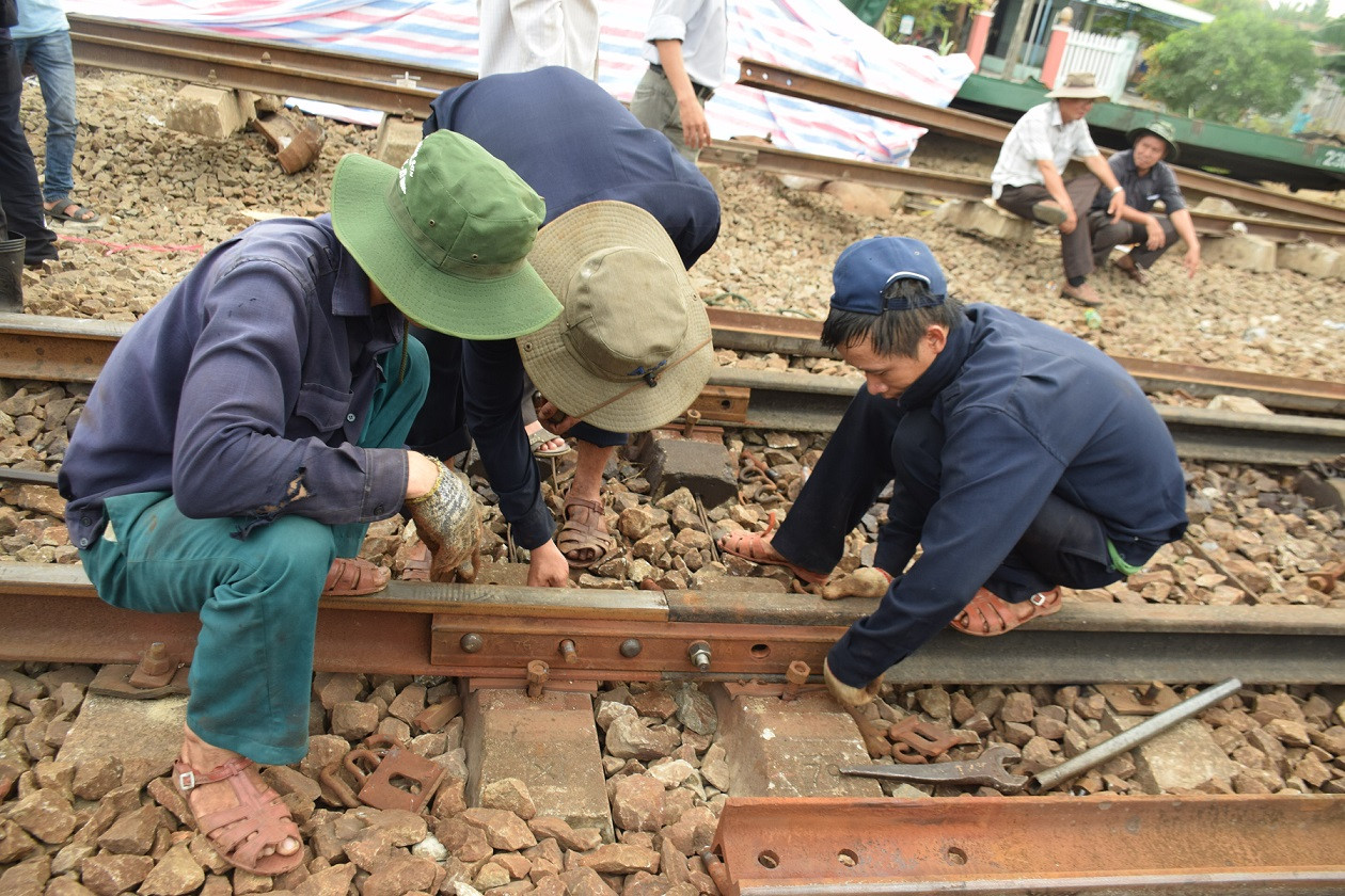 Nhân viên đường sắt đang nổ lực sửa chữa lại đường ray khu vực ga Núi Thành. Ảnh: THANH THẮNG