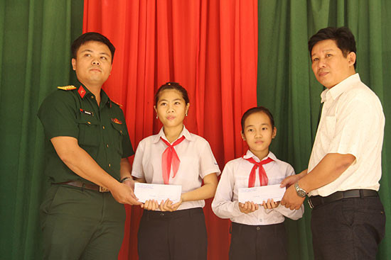 Đại diện Chi đoàn Cơ quan quân sự huyện Nam Giang trao quà hỗ trợ cho 2 học sinh nhận đỡ đầu. Ảnh: ALĂNG NGƯỚC