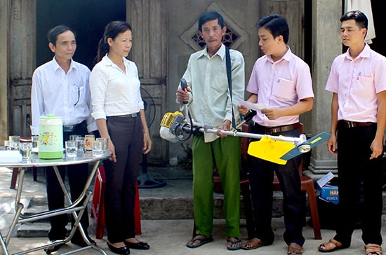 Chi bộ Phòng giao dịch Ngân hàng chính sách xã hội huyện Phú Ninh trao phương tiện sinh kế cho hộ nghèo. Ảnh: Ngọc Lâm