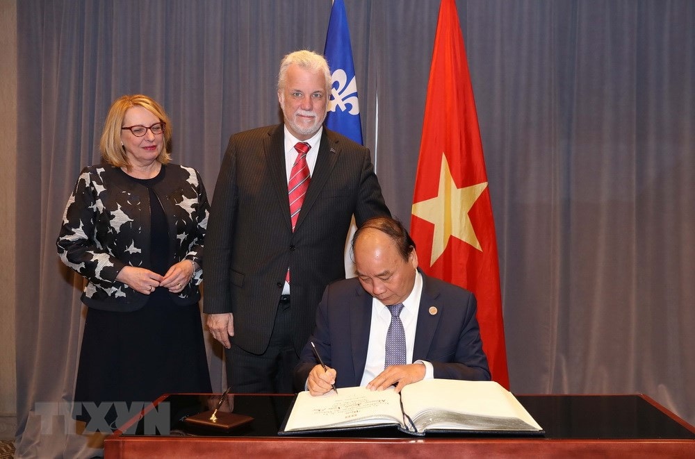 Thủ tướng Nguyễn Xuân Phúc gặp Thủ hiến bang Quebec Philippe Couillard. Trong ảnh: Thủ tướng Nguyễn Xuân Phúc ghi sổ lưu niệm. (Ảnh: Thống Nhất/TTXVN)