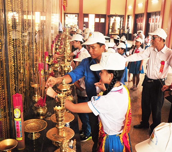 Bí thư Đoàn xã Bình Đào - Trần Hữu Việt cùng học sinh là Cháu ngoan Bác Hồ tiêu biểu của xã dâng hương tại Đền tưởng niệm Anh hùng liệt sĩ huyện.  Ảnh: NG.ĐOAN