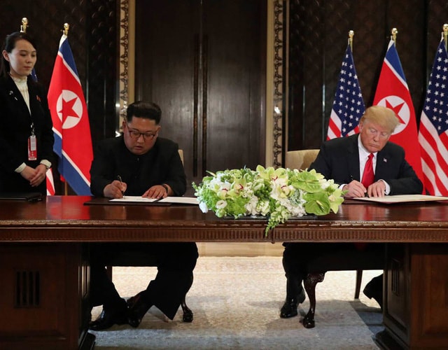 Hai nhà lãnh đạo cùng đặt bút ký vào tuyên bố chung tại Singapore (Ảnh: Reuters)