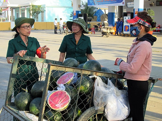 Hai cựu thanh niên xung phong luôn túc trực vận động người dân không họp chợ tự phát. Ảnh: HOÀI NHI