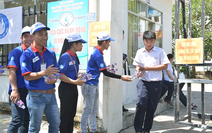 Các bạn tình nguyện viên trao nước cho thí sinh sau khi rời phòng thi. Ảnh: THẮNG NhẬT