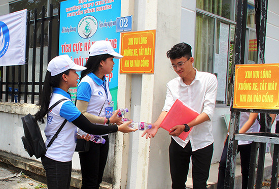 Lực lượng tình nguyện viên TSMT tặng nước suối cho thí sinh tại điểm thi Trường THPT chuyên Nguyễn Bỉnh Khiêm (Tam Kỳ). Ảnh: V.A
