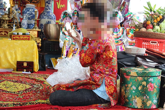 Thanh đồng đang trang điểm để thực hiện nghi thức hầu đồng tại lễ hội truyền thống Bửu đản Thánh Mẫu đệ tam Thoải cung 2018 của đồng bào theo tín ngưỡng thờ Mẫu ở Tam Giang Thánh Điện (thuộc phường Hòa Xuân, quận Cẩm Lệ).