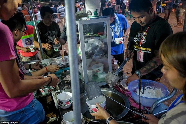 Tình nguyện viên chuẩn bị bữa ăn cho những người có mặt tại hiện trường giải cứu đội bóng bị mắc kẹt. Ảnh: Getty.