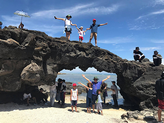 Du khách chụp ảnh lưu niệm tại cổng Tò Vò ở đảo Lớn, huyện đảo Lý Sơn. Ảnh: N.S