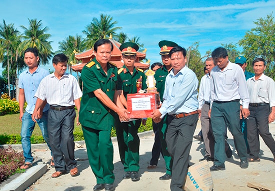 Đại tá Nguyễn Quang Ngọc (mặc quân phục, hàng đầu) trong một lần đưa hài cốt đồng đội từ các tỉnh phía nam về lại đất mẹ Quảng Nam. Ảnh: XUÂN THỌ