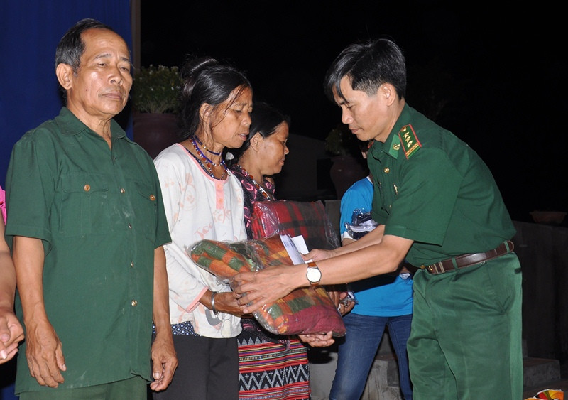 Thượng tá Hoàng Văn Mẫn - Phó Chính ủy Bộ đội Biên phòng tỉnh tặng quà cho người dân xã La Êê. Ảnh: VINH ANH