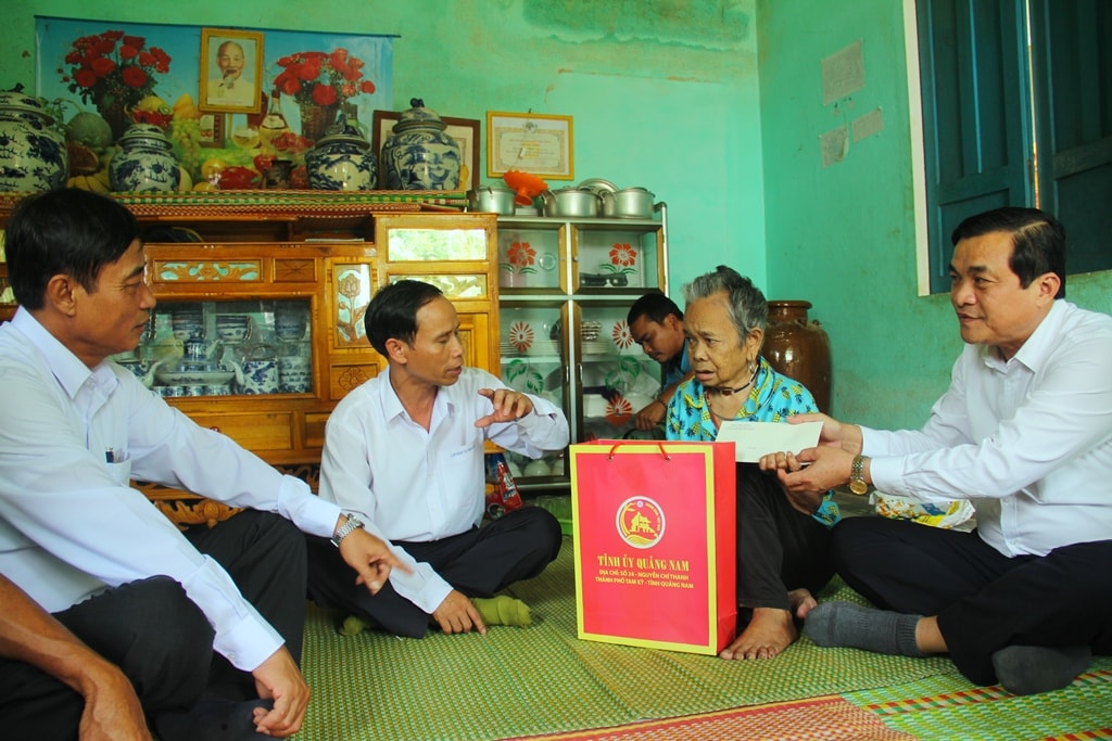 Phó Bí thư Thường trực Tỉnh ủy Phan Việt Cường (ngoài cùng bên phải) thăm hỏi và tặng quà cho cụ bà Alăng Bhơ - thân nhân liệt sĩ tại thôn Adinh 1 (thị trấn P rao). Ảnh: A.N