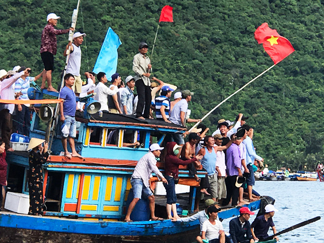 Rất đông người dân từ đất liền ra cổ vũ cho các thuyền đua. Ảnh: MINH HẢI