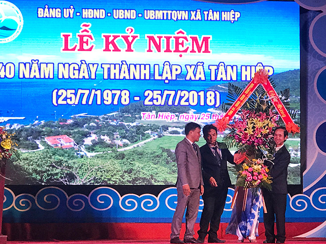 Phó chủ tịch HĐND tỉnh, ông Võ Hồng tặng hoa chúc mừng Đảng bộ, chính quyền và nhân dân xã đảo. Ảnh: MINH HẢI