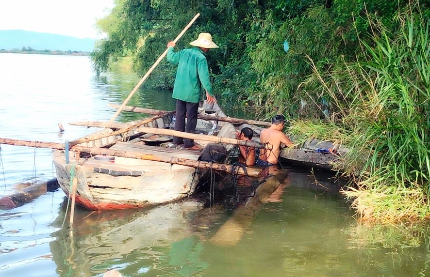 Trục vớt số gỗ tang vật do các đối tượng bỏ lại dưới sông Thu Bồn. Ảnh: M.M